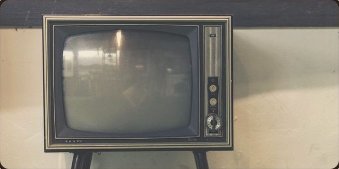 A wood-trimmed television set from the 1960s with a rotary dial beside the screen